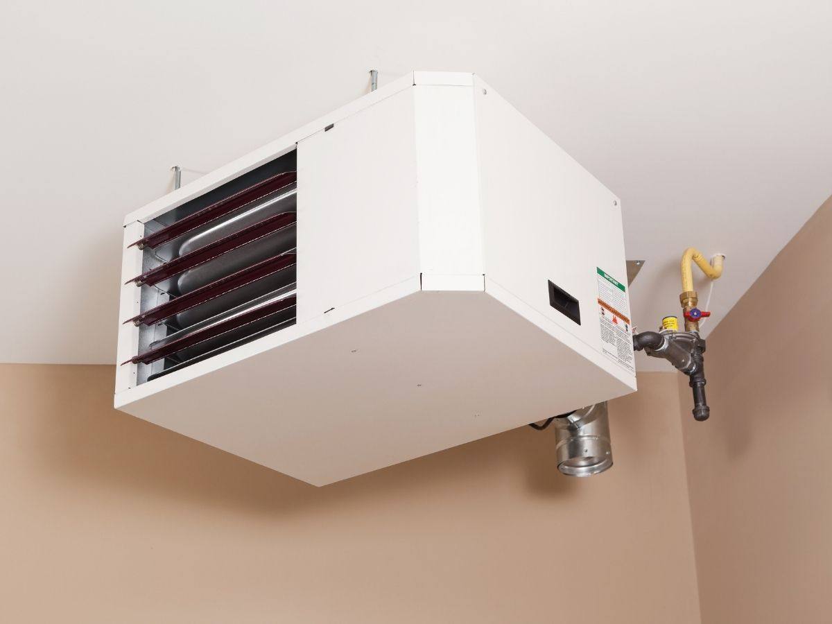 Gas unit heater hung from the ceiling with its gas supply line